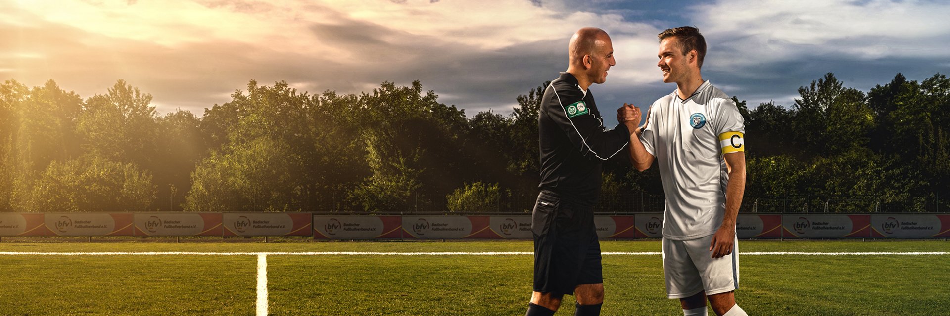 Schiedsrichter und ein Fußballspieler, die sich die Hand geben.