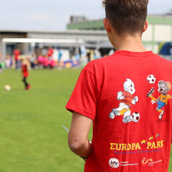 Ein FSJ-ler von hinten. Er trägt ein rotes T-Shirt.