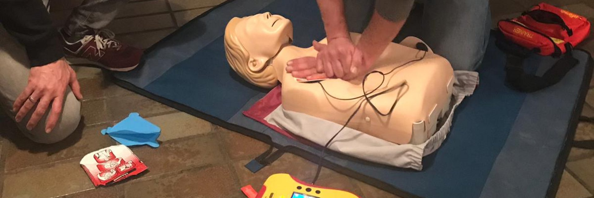 Ein Mann gibt einer Übungspuppe eine Herzdruckmassage.