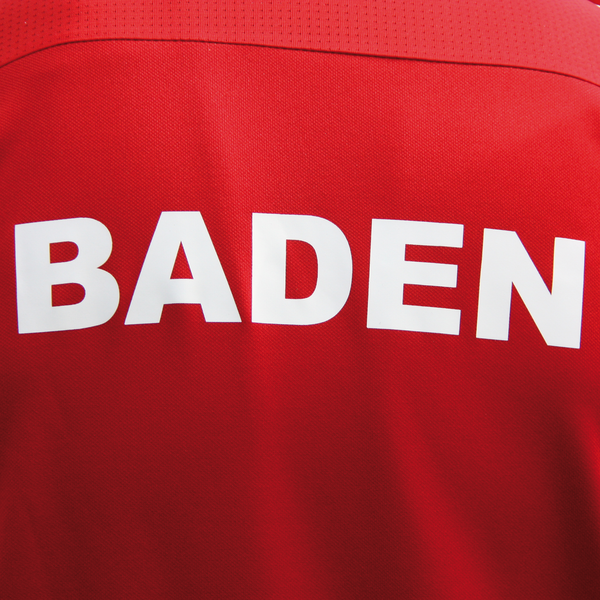 Eine Person von hinten, die ein Oberteil mit der Aufschrift "Baden" trägt.