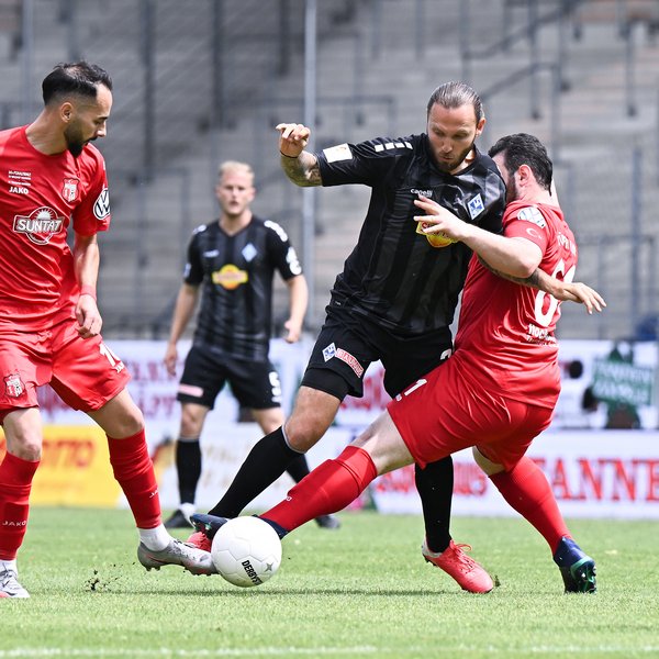 Ein Spieler in schwarz versucht, sich gegen zwei Gegner in rot durchzusetzen. 