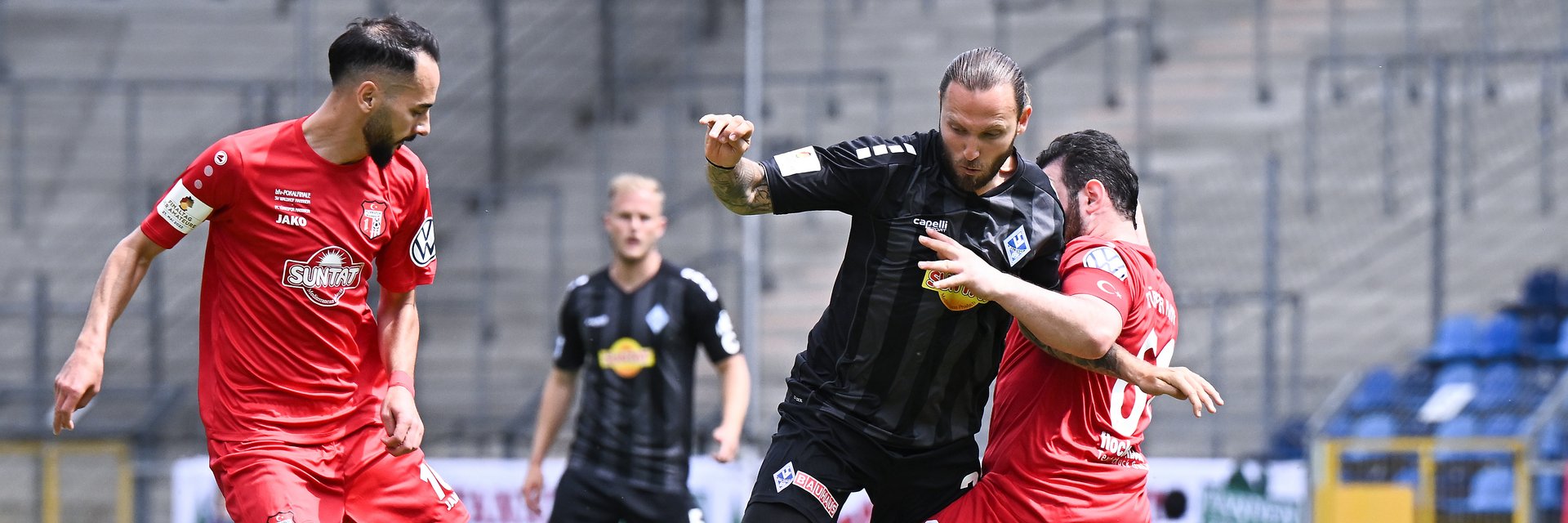 Ein Spieler in schwarz versucht, sich gegen zwei Gegner in rot durchzusetzen. 