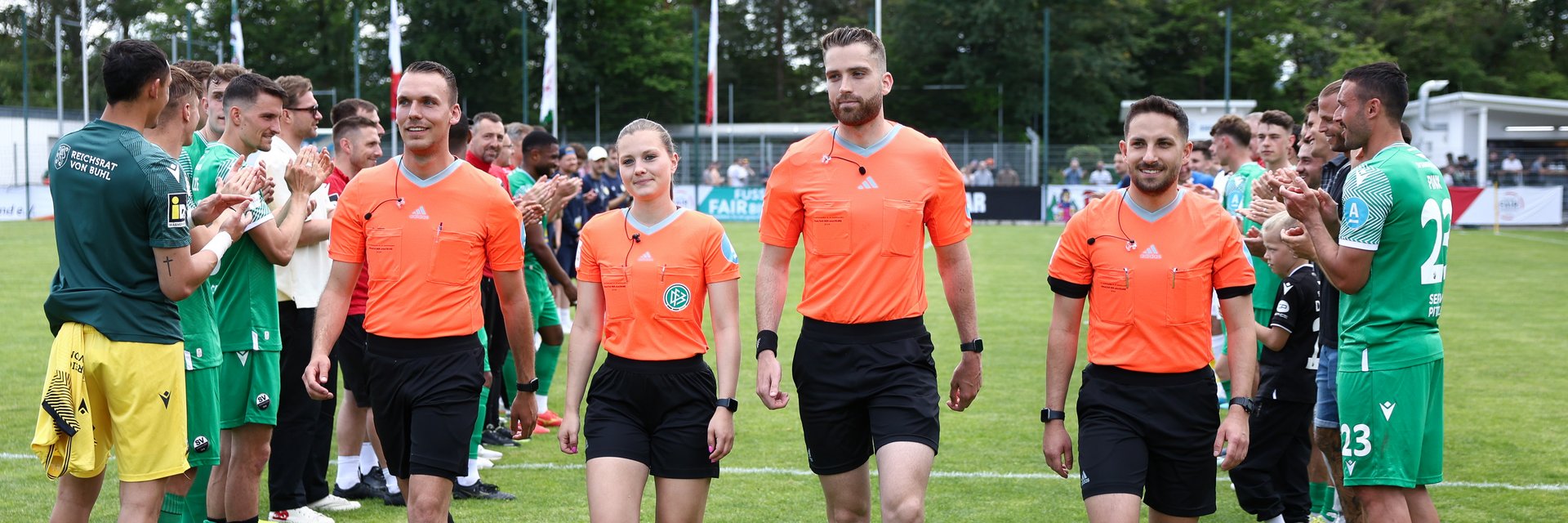 Schiri-Team des Pokal Finals der Herren. Sie laufen nebeneinander zur Siegerehrung.