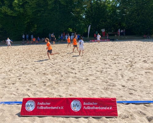 Jugendliche, die auf der Sportschule Schöneck im Sand Beachsoccer spielen.